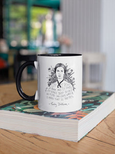 Taza blanca con asa negra con ilustración y cita de Emily Dickinson en inglés.