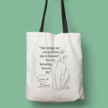 Cargar imagen en el visor de la galería, Tote bag color natural con asa negra de la colección Quotes &amp; Co con ilustración de silueta de mujer y cita de Simone de Beauvoir.
