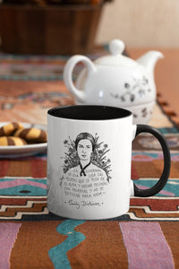 Taza blanca con asa negra con ilustración y cita de Emily Dickinson en español.