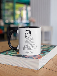 Taza blanca con asa negra con ilustración y cita de Stefan Zweig en inglés.