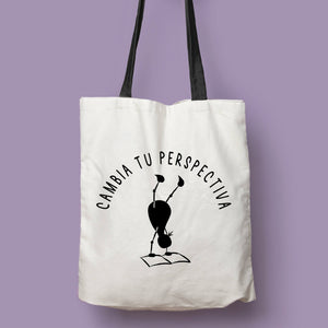 Tote bag natural con asa negra con la ilustración del personaje Lectorix y el texto "Cambia tu perspectiva"