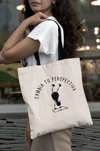 Tote bag natural con asa negra con la ilustración del personaje Lectorix y el texto "Cambia tu perspectiva"