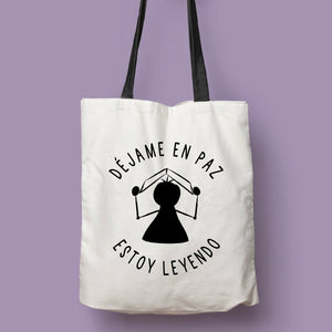 Tote bag natural con asa negra con la ilustración del personaje Lectorix y el texto "Déjame en paz, estoy leyendo"