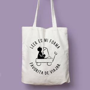 Tote bag natural con asa natural con la ilustración del personaje Lectorix y el texto "Leer es mi forma favorita de viajar"