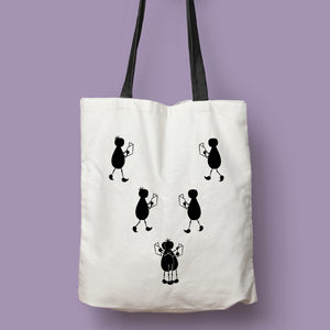 Tote bag natural con asa negra de la colección Lectorix con una pareja de figuras leyendo y abrazándose.