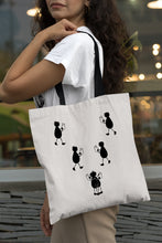 Cargar imagen en el visor de la galería, Tote bag natural con asa negra de la colección Lectorix con una pareja de figuras leyendo y abrazándose.